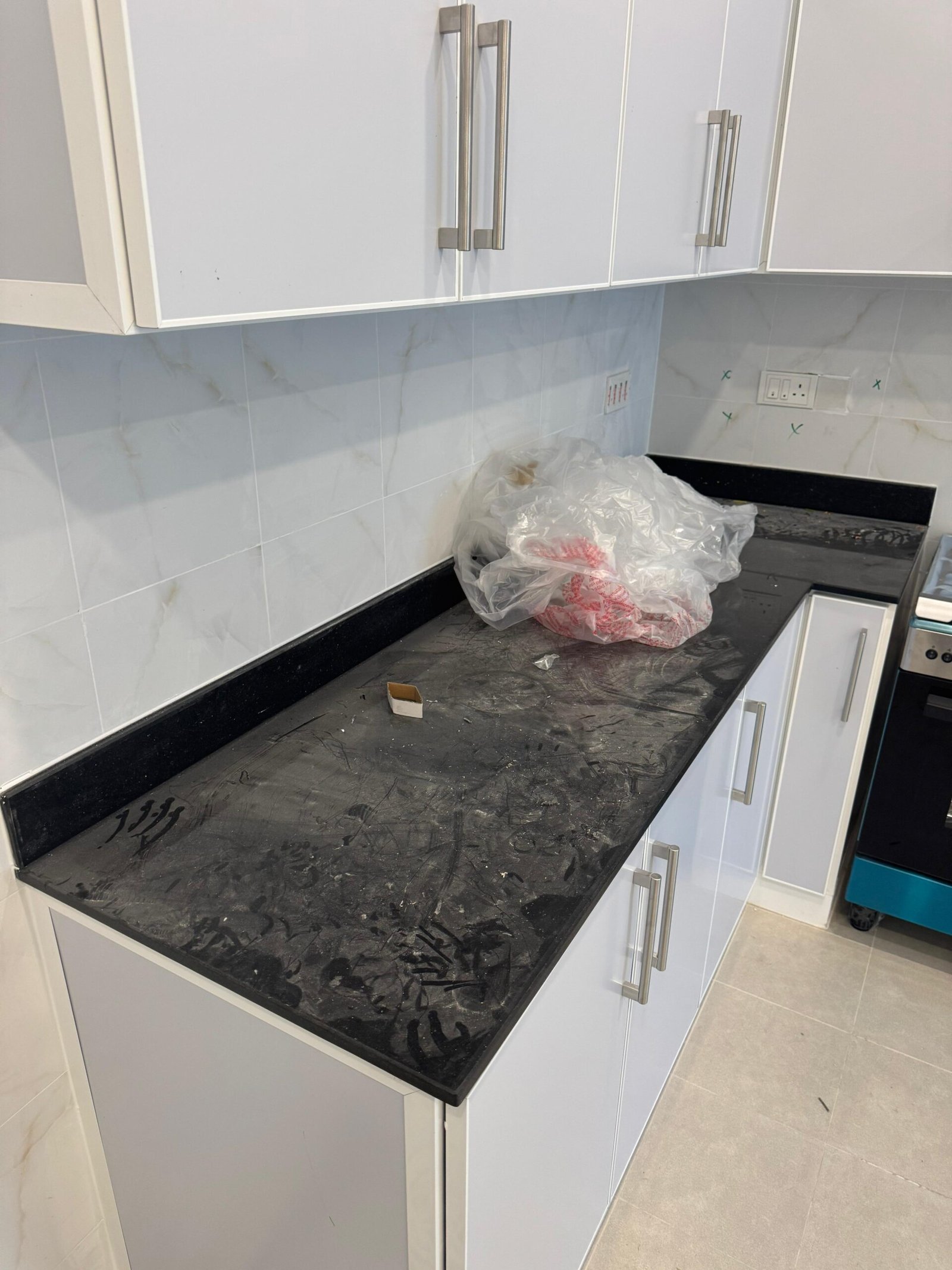 أرضية رخام نصفها متسخ بالإسمنت والنصف الآخر لامع بعد التنظيف